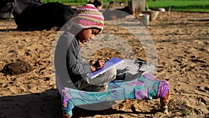 Poor school child, adorable teenage boy writing on copybook, doing homework outdoors. Back to school concept. Children. Lifestyle