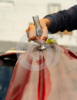 Poor Spaniard fixes the bumper of his car with a hammer. Madrid photo