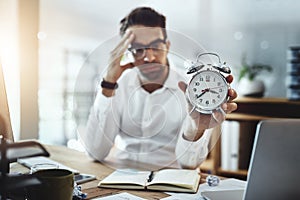 Poor time management will land you in the deep end. Portrait of a young businessman looking stressed out while holding a