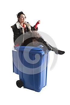 Poor woman near trash can