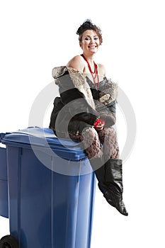 Poor woman near trash can