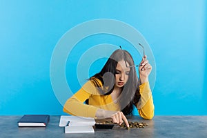 A poor young girl counts money at home at her desk, hoping that she will have enough for all expenses