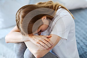 Poor young woman crying at home