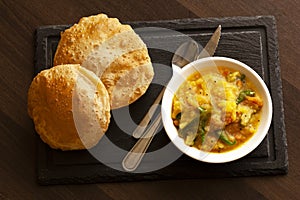 Poori with potato curry on slate background