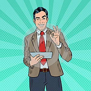 Pop Art Businessman with Tablet Gesturing OK and Winking
