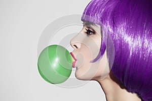 Pop art woman portrait wearing purple wig. Blow a green bubble