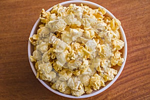 Popcorn in bowl. Brown background