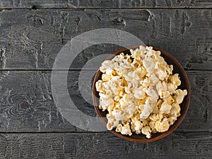 Popcorn in a clay bowl. Place for your text. The view from the top.