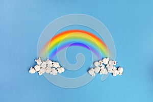 Popcorn clouds on a blue background with the colorful rainbow