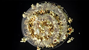 Popcorn drops into a big bowl. Filmed on a high-speed camera at 1000 fps.