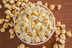 Popcorn in bowl. Brown background