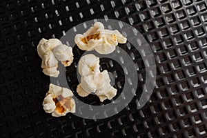 Popcorn grains popped in top view, and closeup and black textured background