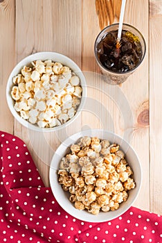 Popcorn and ice cola on wood background.