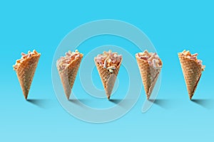 Popcorn in ice cream cones on blue background.