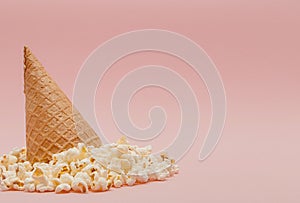 Popcorn in ice cream cones on pink background