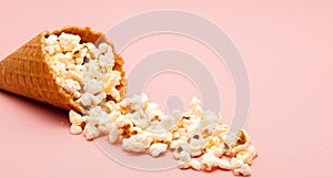 Popcorn in ice cream cones on pink background