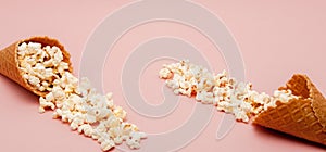 Popcorn in ice cream cones on pink background. Top view