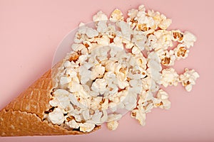 Popcorn in ice cream cones on pink background. Top view