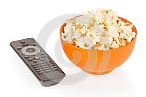 Popcorn in a orange bowl and remote control