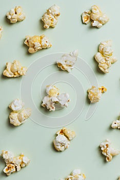 The popcorn in paper cup on green background.