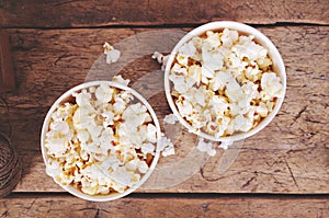 Popcorn in paper cups on wooden surface. Top view