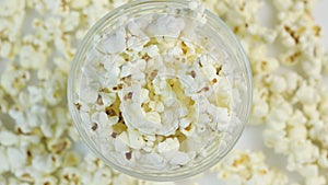 Popcorn in a plate in the center of the frame, rotating on a popcorn background. Place for text.
