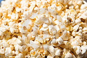 Popcorn in a plate close-up. Blue background