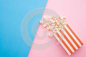 Popcorn in red bag on colorful blue pink background, flatlay still life minimal style