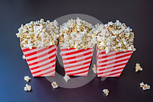 Popcorn in red and white container on a dark background