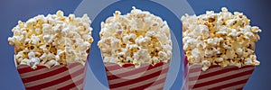 Popcorn in red and white container on a dark background BANNER, LONG FORMAT