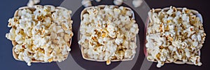 Popcorn in red and white container on a dark background BANNER, LONG FORMAT