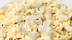 Popcorn salted corn, cooked, in white, bowl, rotation counterclockwise, turning, close-up.