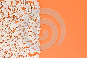 Popcorn scattered at half the orange background background and a space for copyspace