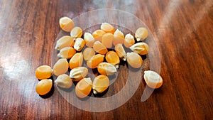 Popcorn seeds on wooden background.