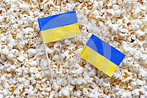 Popcorn texture background and Ukraine flags. The concept of sports competitions, movie time, holidays in the Ukraine