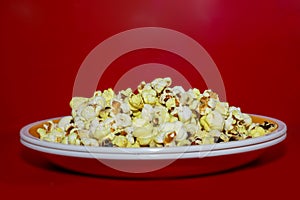 Popcorn viewed from above on red background. Flat lay of pop corn bowl