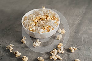 popcorn in a white plate on a concrete background