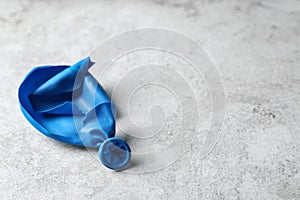 Popped balloon on grey background
