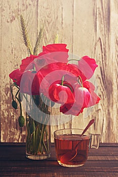 Poppy bouquet of flowers and cup of tea