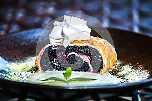 Poppy seed strudel sprinkled with powdered sugar and mint leaf