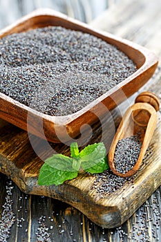 Poppy seeds in a wooden bowl and scoop.