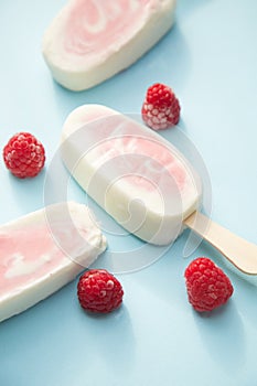 Popsicle with fresh raspberry on a table