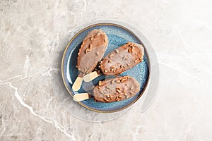 Popsicle, ice cream covered with chocolate on plate. Top view