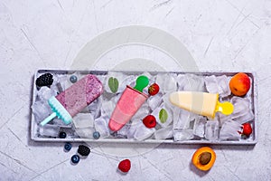 Popsicles ice cream with fruits and berries on copy space background, summer dessert, natural homemade sweets