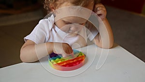 Popular Anti stress toy Pop It. Child Playing With The Pop It Fidget Toy. Happy childhood, popular educational games.