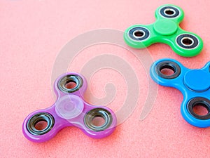 Popular colourful fidget spinner toy on a colored background