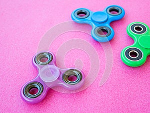 Popular colourful fidget spinner toy on a colored background