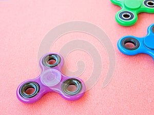 Popular colourful fidget spinner toy on a colored background