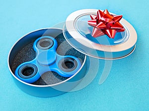 Popular colourful fidget spinner toy in a gift box on a colored background