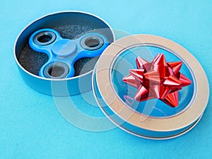 Popular colourful fidget spinner toy in a gift box on a colored background